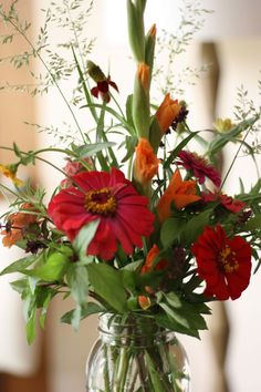 a vase filled with red and orange flowers