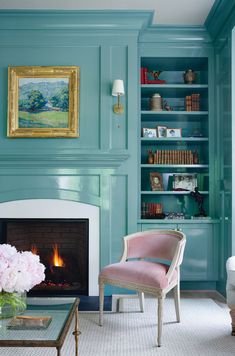 a living room filled with furniture and a fire place in front of a book shelf