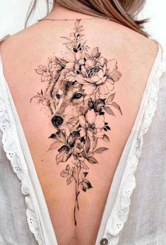 a woman's back with flowers and a wolf on it