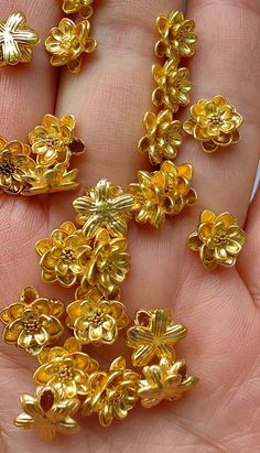 a person holding some gold colored flowers in their hand