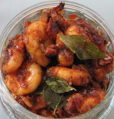 a glass bowl filled with fried shrimp and greens