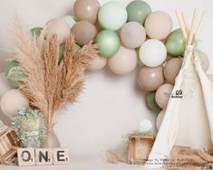 a birthday party with balloons, cake and teepees on the table in front of it