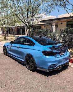 a blue car parked in front of a house