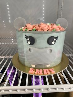 a cake decorated with an animal's face on top of a shelf in a refrigerator