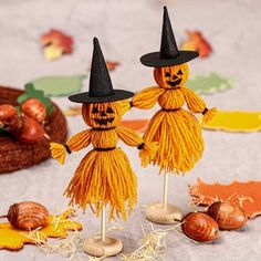 two scarecrows with black hats and tassels are standing next to nuts