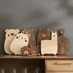 the wooden bears are lined up on the shelf in front of the dresser and drawers