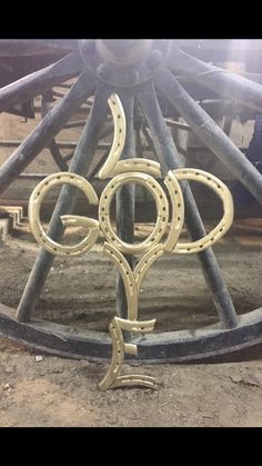 an old wagon wheel with the word go written on it's side and two horseshoes in the center