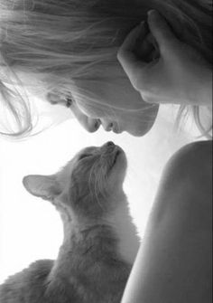 a woman is petting a small orange cat