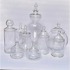 an assortment of glass jars and lids on a white background