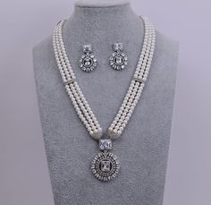 A Swarovski necklace set in premium quality white pearls exudes luxury and elegance, making it the perfect choice for any occasion. Necklace Length: 12.5" with adjustable chain Earrings Push-Back closure. Earring Lenght: Studs 1.25" Sterling Silver finish on high-quality brass as a base metal. Availability: In-Stock. *Color may vary slightly due to light condition & photography. Jewelry Care:  Keep away from moisture. Allow perfumes and lotion to dry before wearing. Store in jewelry pouch. Clean Pakistani Jewelry Bridal, Diamond Long Necklace, Long Necklace Indian, Statement Wedding Jewelry, Contemporary Bracelets, Photography Jewelry, American Diamond Necklaces, Contemporary Necklace, Contemporary Earrings