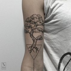 a man's arm with a tree and triangle tattoo on the left inner arm