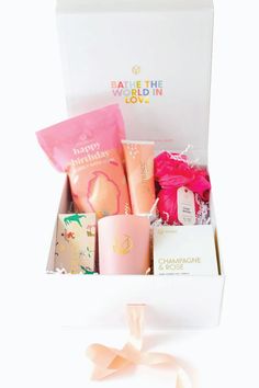 an open gift box filled with pink and white items