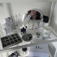 a woman taking a selfie in front of a mirror on top of a shelf