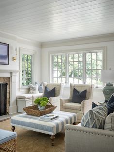 a living room filled with furniture and a fire place in front of a tv mounted on the wall