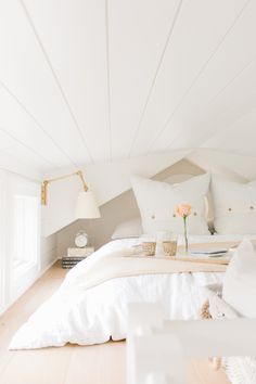 a bed with white sheets and pillows in a room