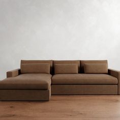 a brown couch sitting on top of a wooden floor