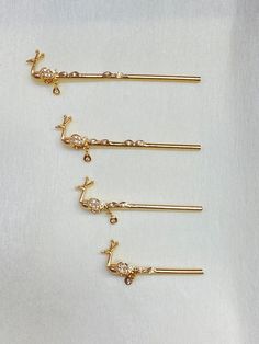 four gold hair pins with crystal details on each one, and a single diamond in the middle