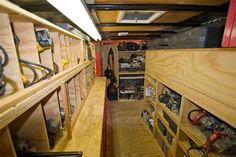 the inside of a truck with lots of wood shelves and tools on it's sides