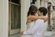 a man and woman embracing each other on the street