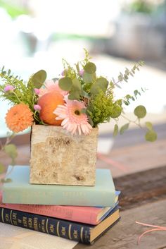 three books stacked on top of each other with flowers and fruit in the middle,