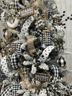 a christmas tree decorated with black and white plaid ribbon, deer ornaments, and burlocks