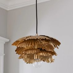 a light fixture hanging from the ceiling in a room with white walls and flooring