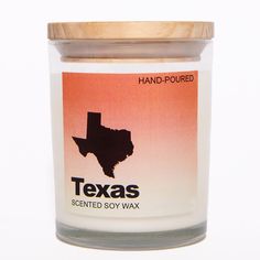 a candle that is sitting in front of a white background with the words texas printed on it