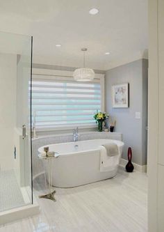 a large white bathroom with a tub and shower