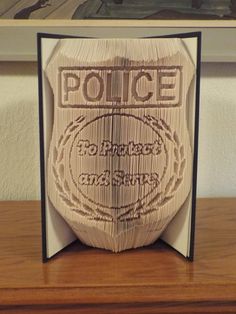 a police badge made out of paper on top of a wooden table