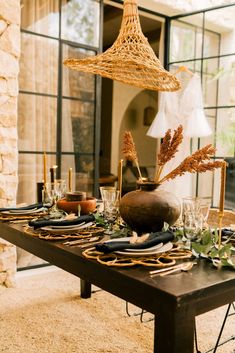 the table is set with plates, glasses and vases for an elegant dinner party