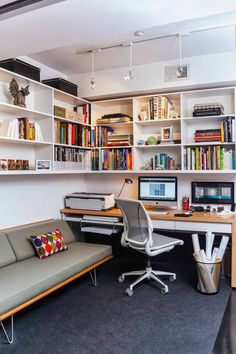 a home office with bookshelves, desk and couch in front of the computer