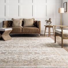 a living room filled with furniture and a large rug on the floor in front of a couch