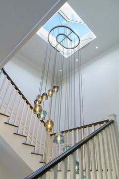 a stair case with glass balls hanging from it's sides and a skylight above