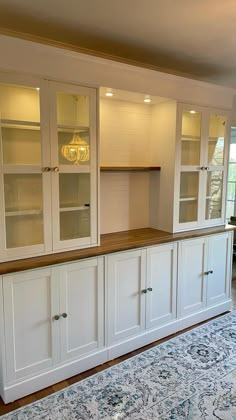 an empty room with white cabinets and blue rug