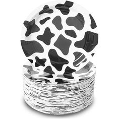 black and white cow print plates stacked on top of each other in front of a white background