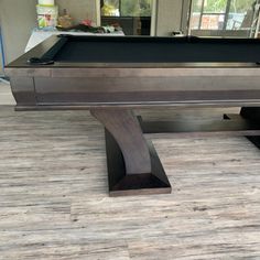 a pool table with a black cloth on the top and one piece of wood at the bottom