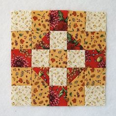 a patchwork square with flowers and leaves on it