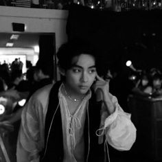 a black and white photo of a woman talking on a cell phone in a restaurant