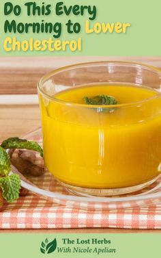 a glass cup filled with orange juice on top of a table