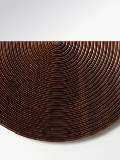 a close up of a wooden object on a white surface with lines in the center