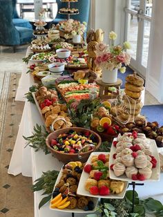 a table filled with lots of different types of food and desserts on top of it