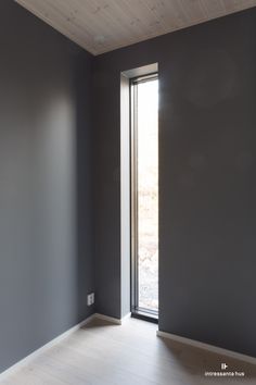 an empty room with grey walls and wooden floors