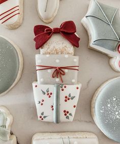 decorated cookies with bows and ribbons on them are displayed in front of other christmas themed cookies