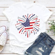 a white shirt with an american flag and fireworks on it