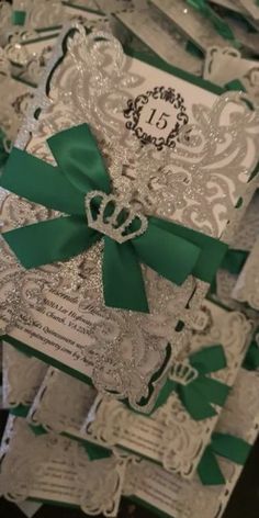 some white and green wedding cards with bows on top of each card is covered in glitter