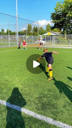 a young boy kicking a soccer ball on top of a field