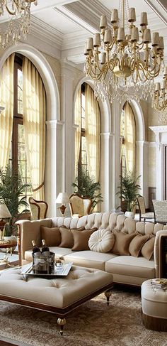 an elegant living room with chandeliers and large windows