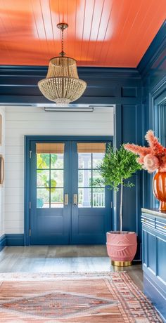 an entryway with blue walls and orange accents