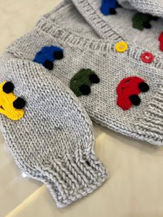 two knitted sweaters with different colored buttons on them