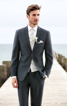 a man in a suit standing on a pier